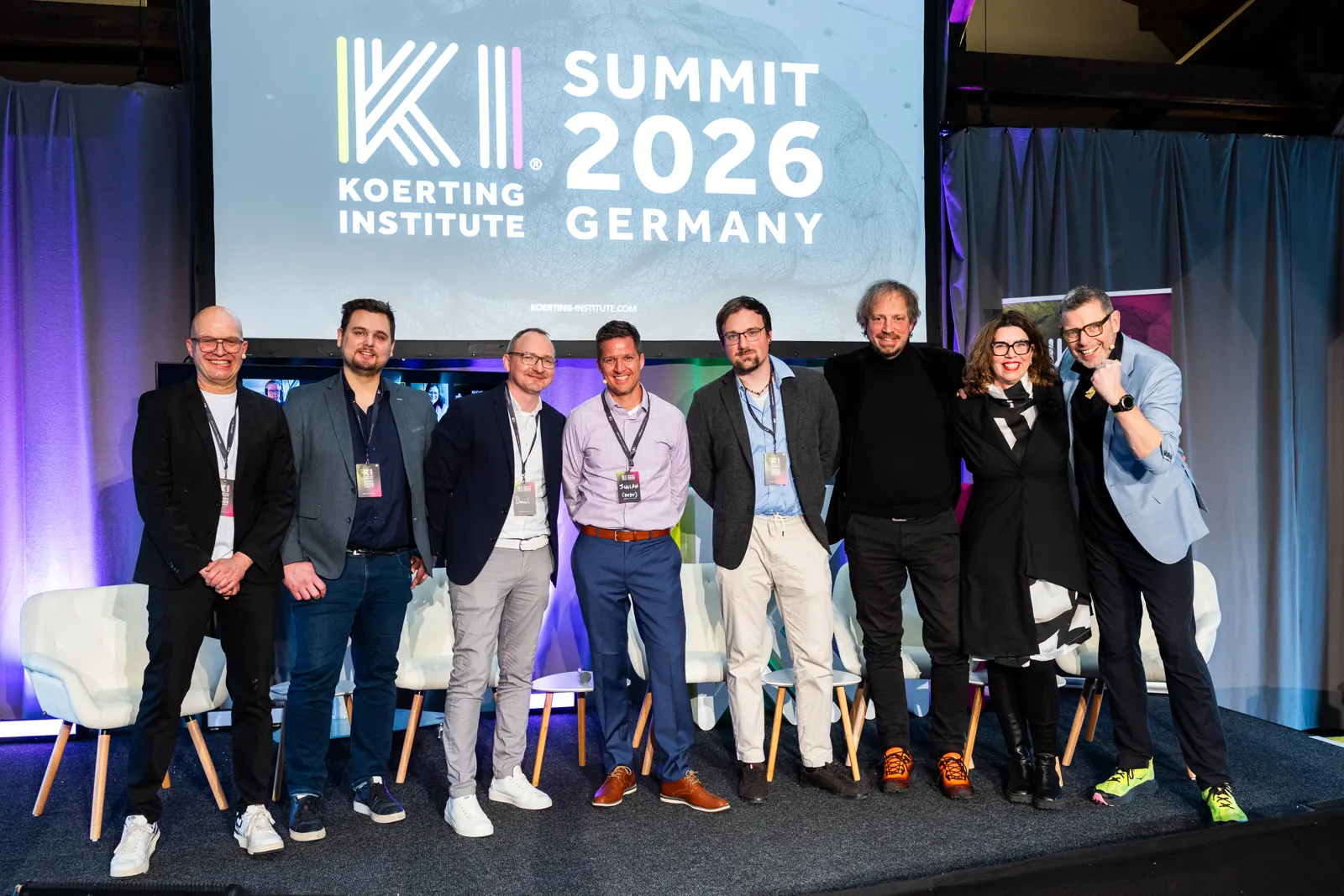 Gruppenfoto auf der Bühne vor dem Banner des KI-Summit 2026